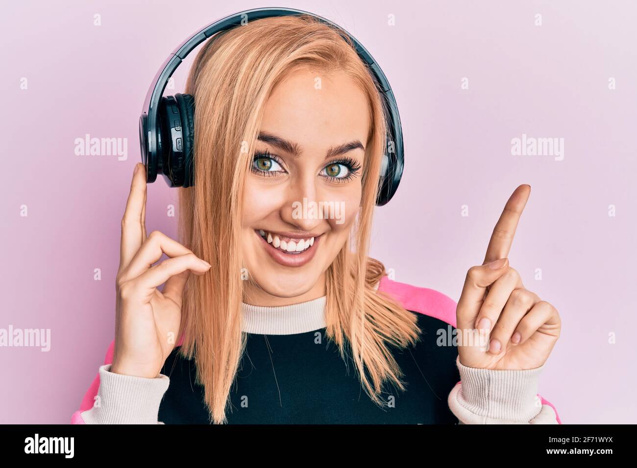Beautiful caucasian woman listening to music using headphones smiling ...
