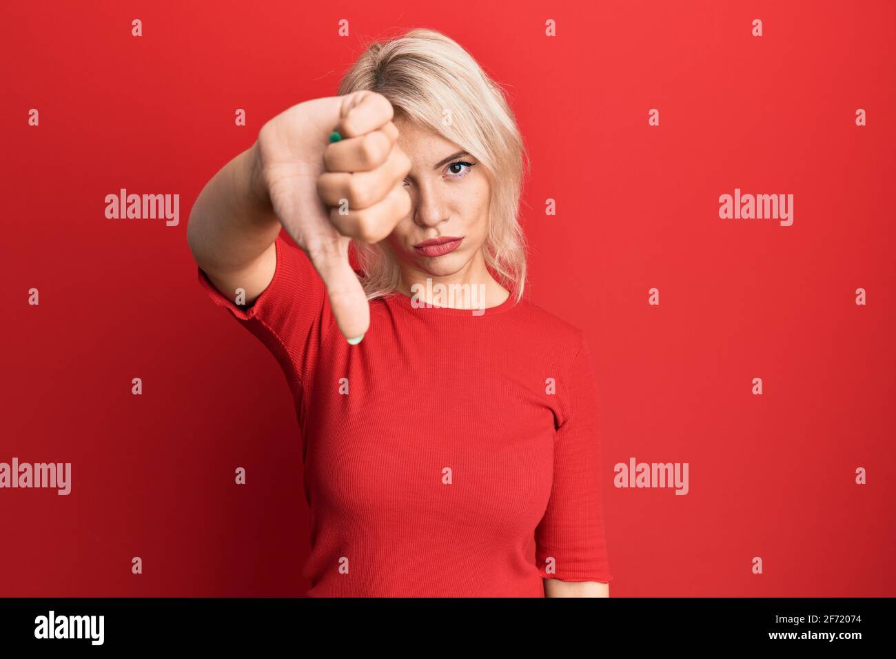 Young blonde girl wearing casual clothes looking unhappy and angry ...