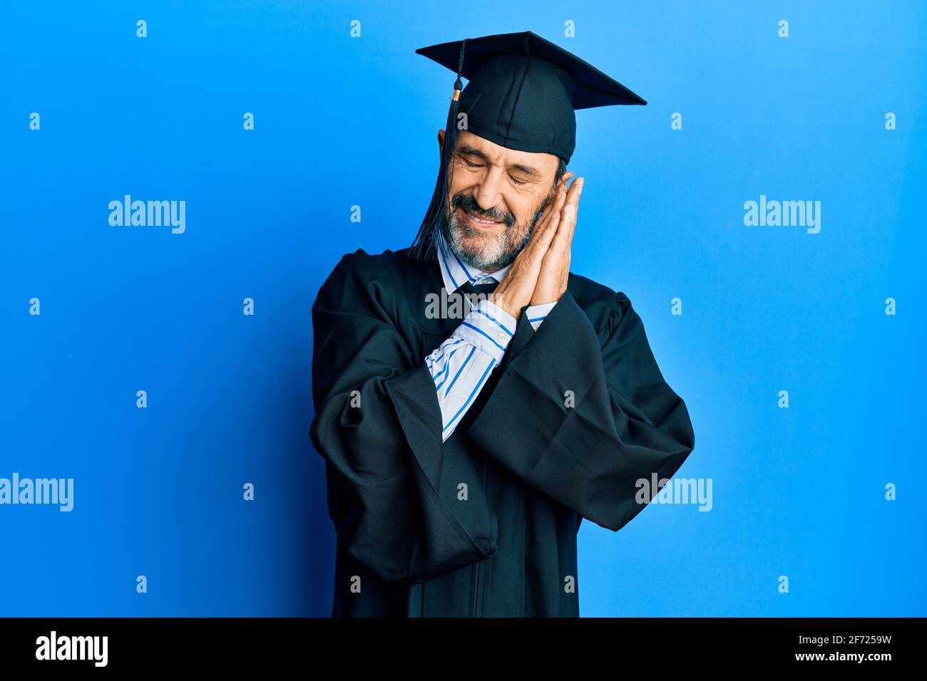 Middle age hispanic man wearing graduation cap and ceremony robe ...