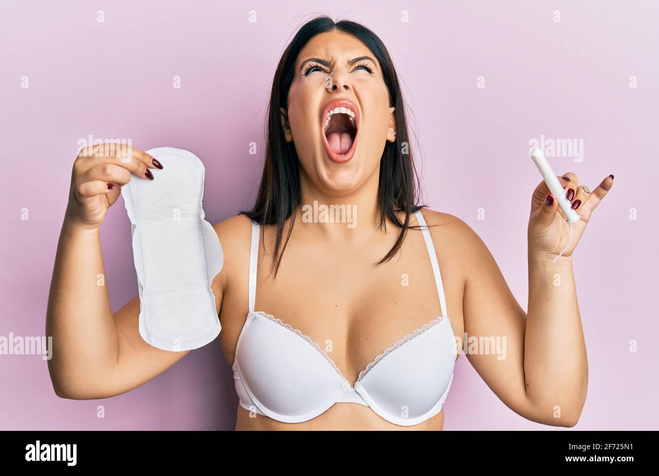 Beautiful brunette woman holding sanitary pad and cotton tampon angry and  mad screaming frustrated and furious, shouting with anger looking up Stock  Photo - Alamy