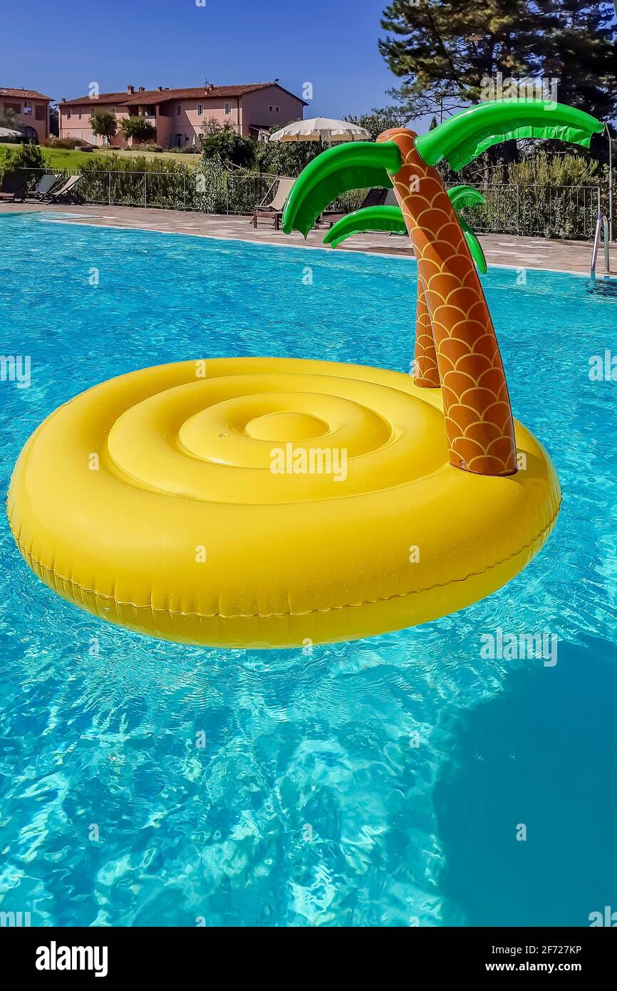 An inflatable in the shape of a desert island with palm trees floats in a swimming  pool of a tourist resort in the countryside Stock Photo - Alamy