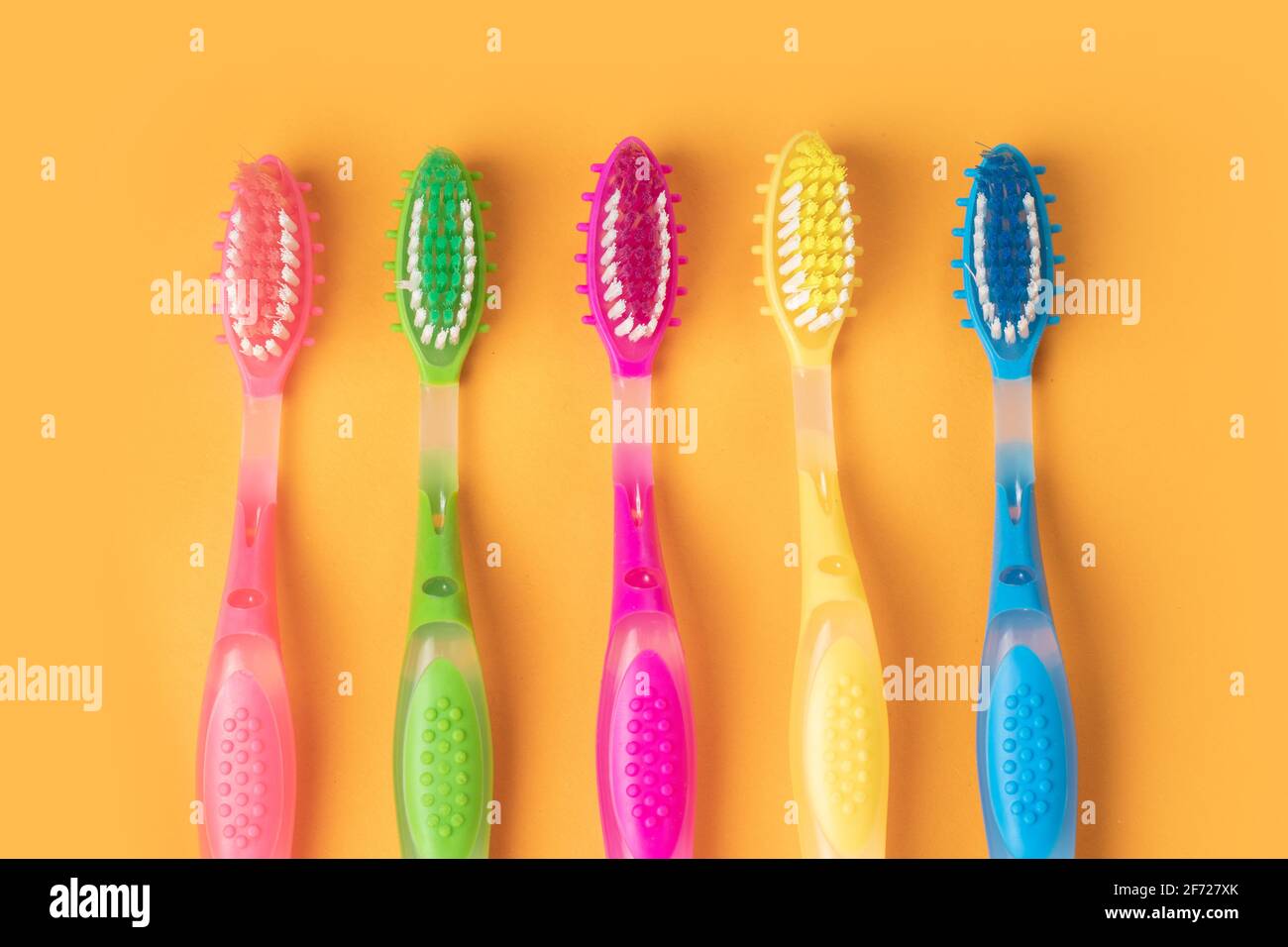 Colorful Toothbrushes on yellow background Stock Photo - Alamy