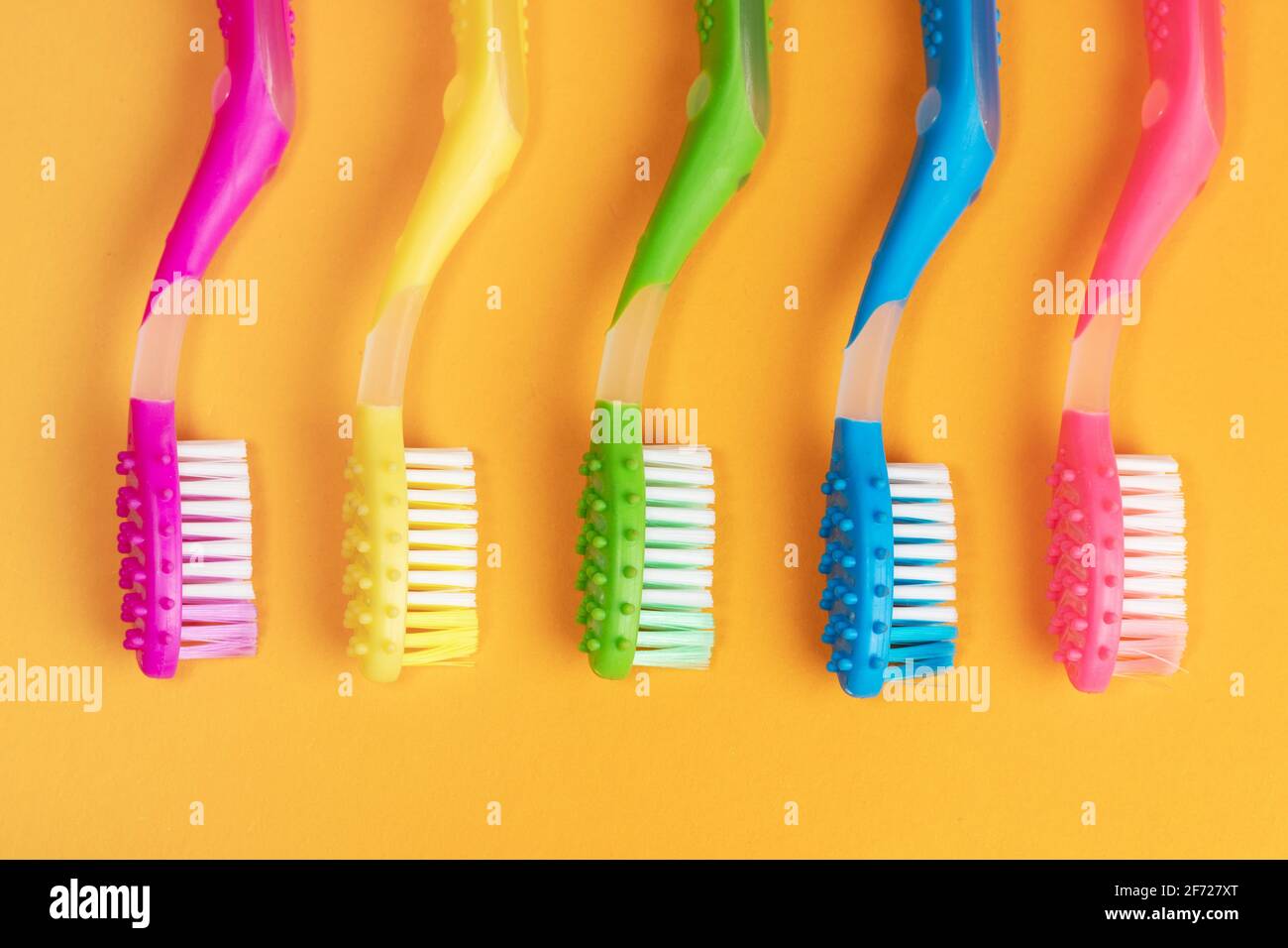 Colorful Toothbrushes on yellow background Stock Photo - Alamy