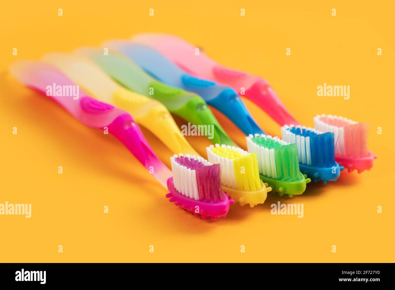 Colorful Toothbrushes on yellow background Stock Photo - Alamy