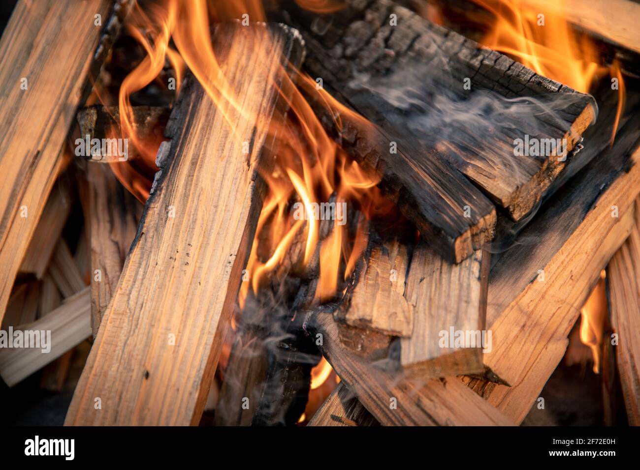 Closeup of pyre of burning wood with flames. Production of charcoal for