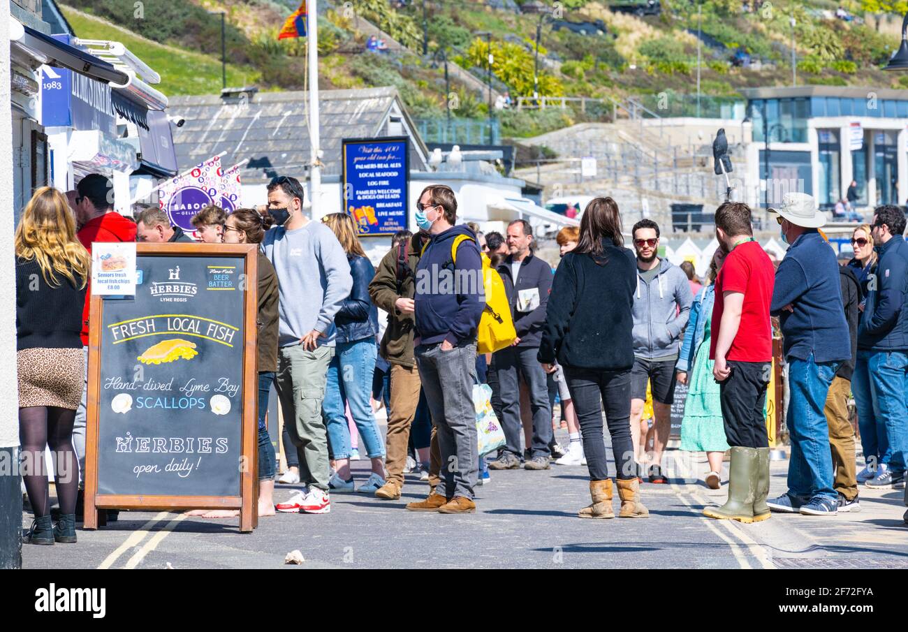 Lyme Regis, Dorset, UK. 4th Apr, 2021. UK Weather. Easter Sunday: People queue up at takeaway food stalls at Lyme Regis on a warm and sunny Easter Sunday Credit: Celia McMahon/Alamy Live News Stock Photo