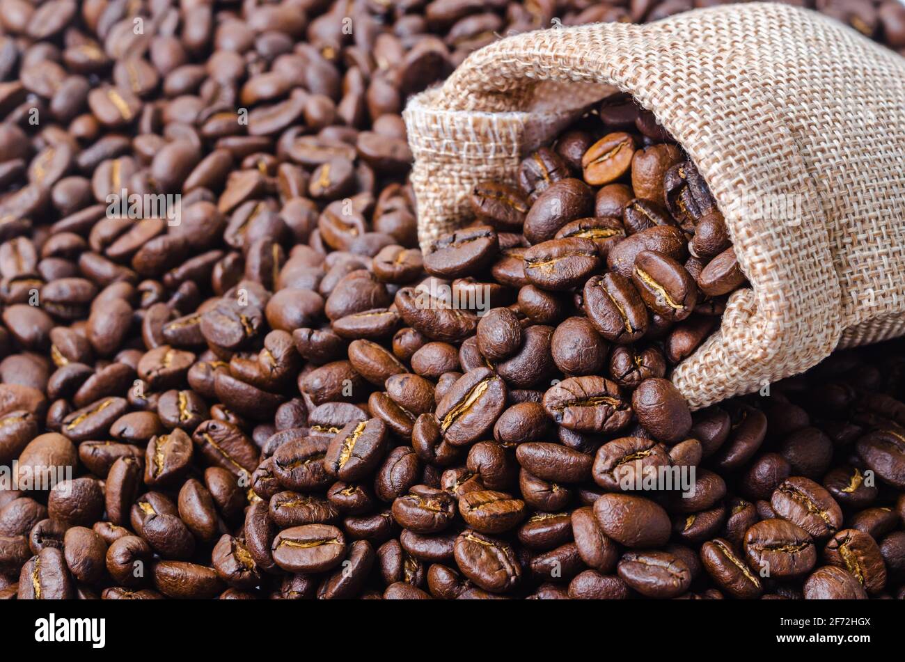 Coffee beans in sack bag on coffee beans background Stock Photo - Alamy