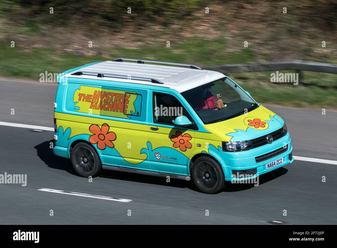 2014 VW Transporter T28 Startline Tdi caravelle. The Mystery Machine Scooby Doo dog walking service Volkswagen driving on the M6 motorway UK Stock Photo