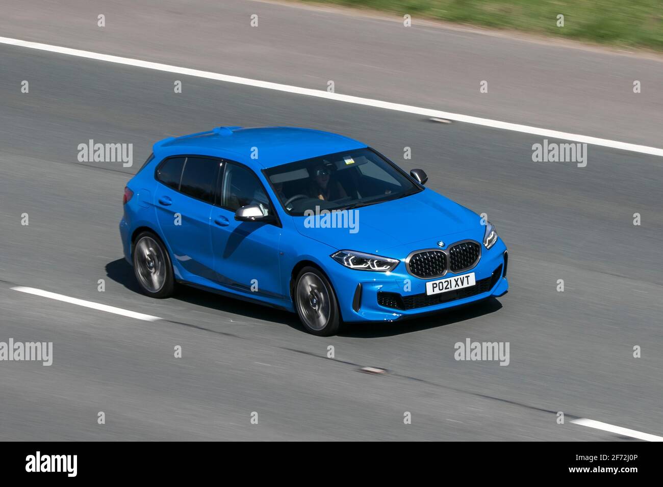 2021 blue BMW M135i Xdrive Auto; moving vehicles, cars, vehicle driving on UK roads, motors, motoring on the M6 English motorway road network Stock Photo