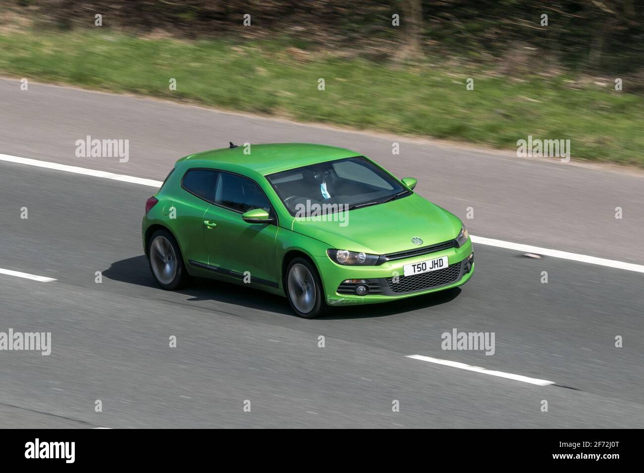 2013 Green VW Volkswagen Scirocco Gt moving vehicles, cars, vehicle driving on UK roads, motors, motoring on the M6 English motorway road network Stock Photo