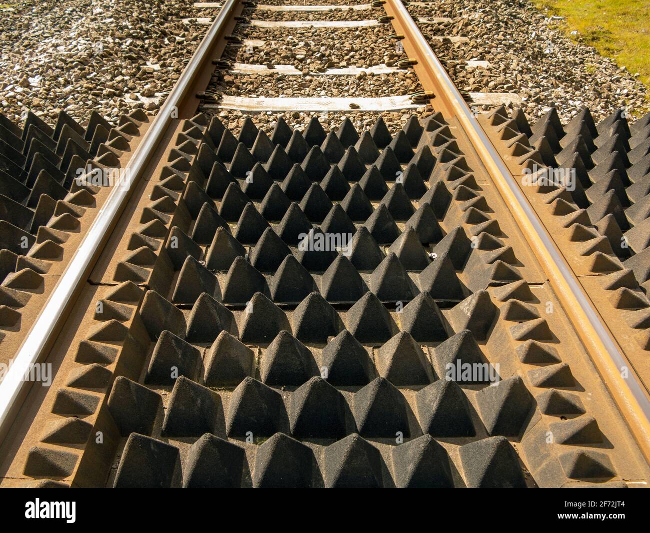 A section of rail track at a footpath crossing showing anti-trespass panels Stock Photo
