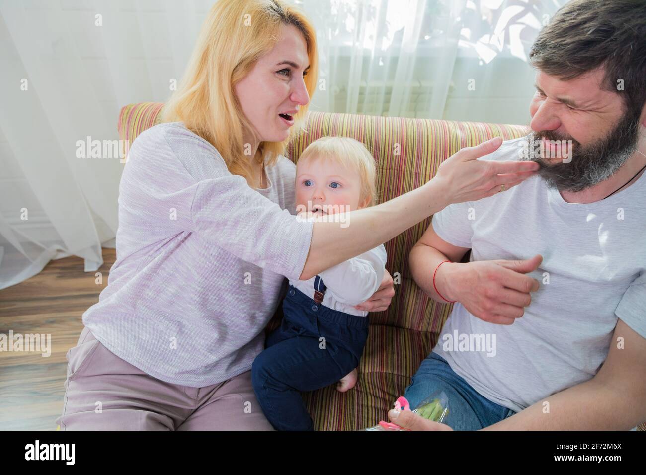 Dad with children congratulate mom on the holiday, mother's day. Have fun, laugh and give flowers Stock Photo