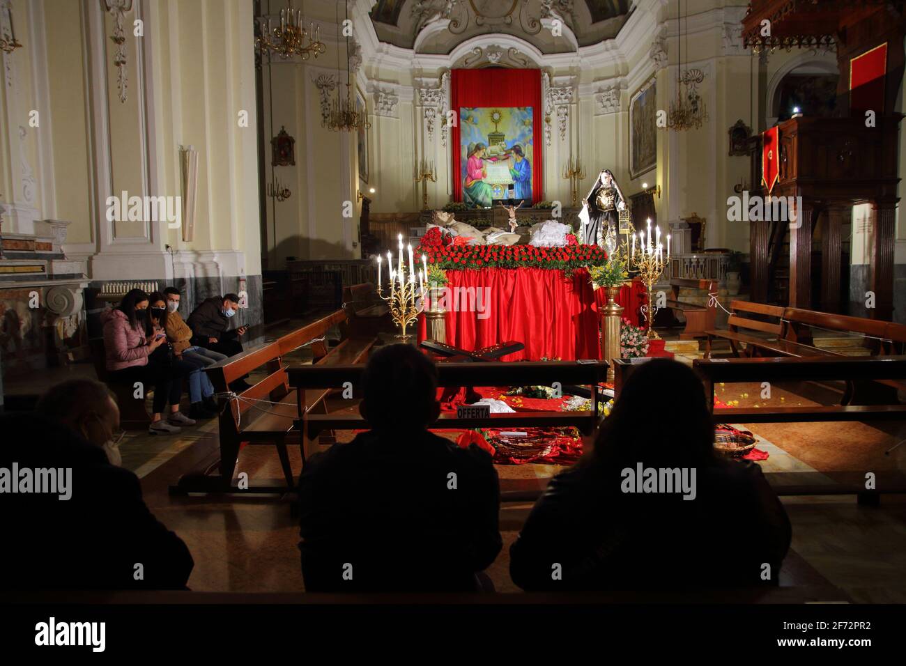 Faithful in prayer before the statues of the dead Christ and the Sorrowful Virgin on Good Friday
