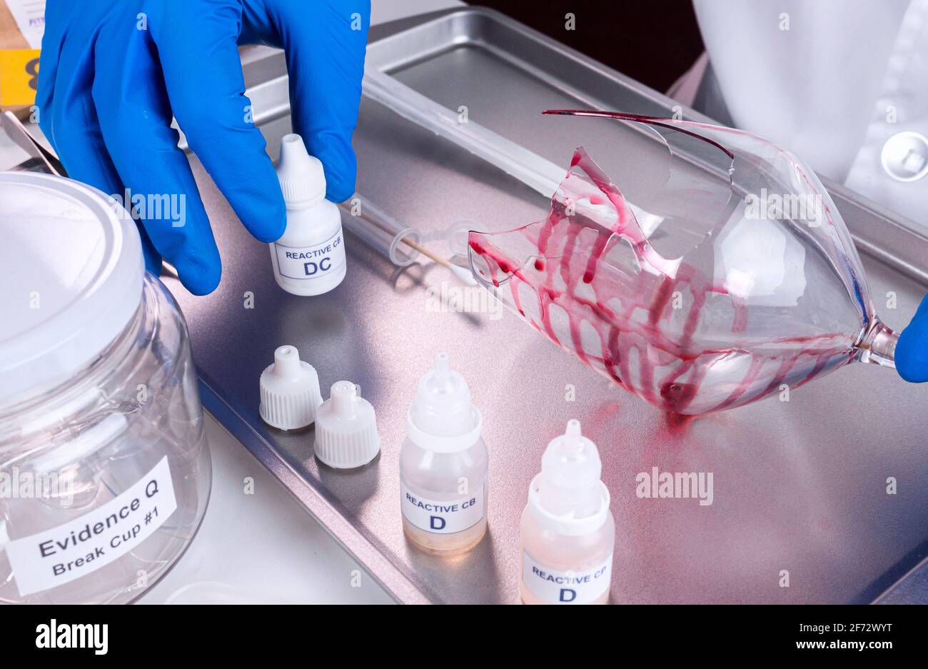 Police expert gets blood sample from a broken glass bottle in