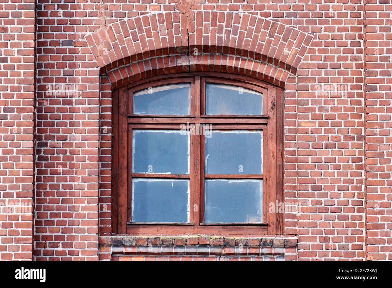 One arched glass window on old red brick wall. Vintage window in brown ...