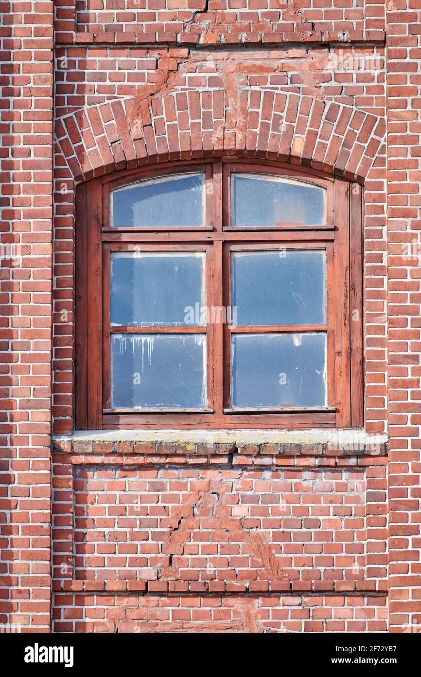 One arched glass window on old red brick wall. Vintage window in brown ...