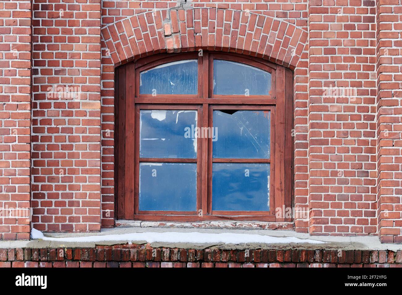 One arched glass window on old red brick wall. Vintage window in brown ...
