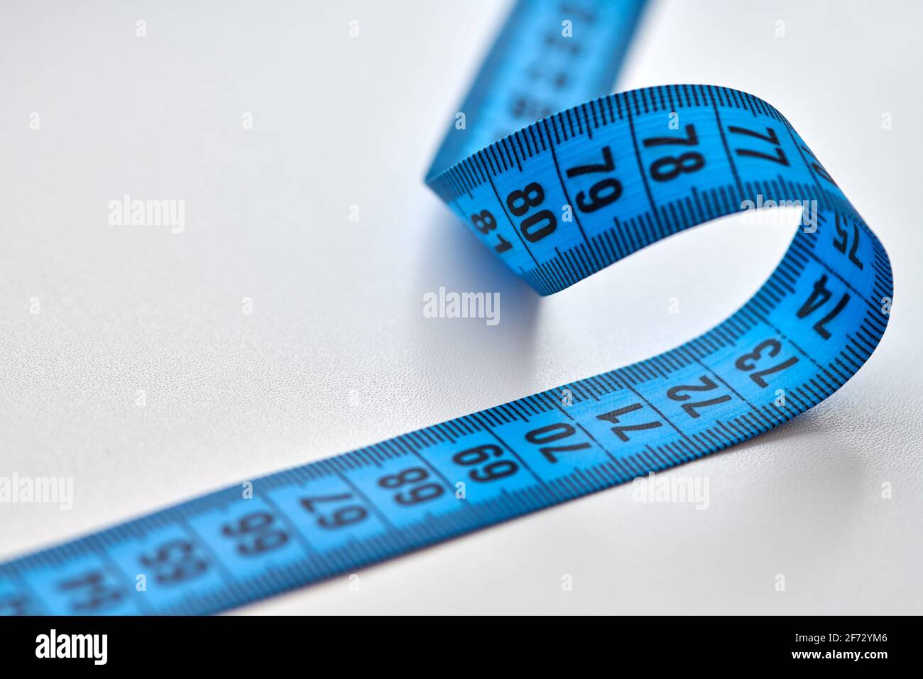 Tailors tape measure cut out against a white background. Blue measuring tape  Stock Photo - Alamy