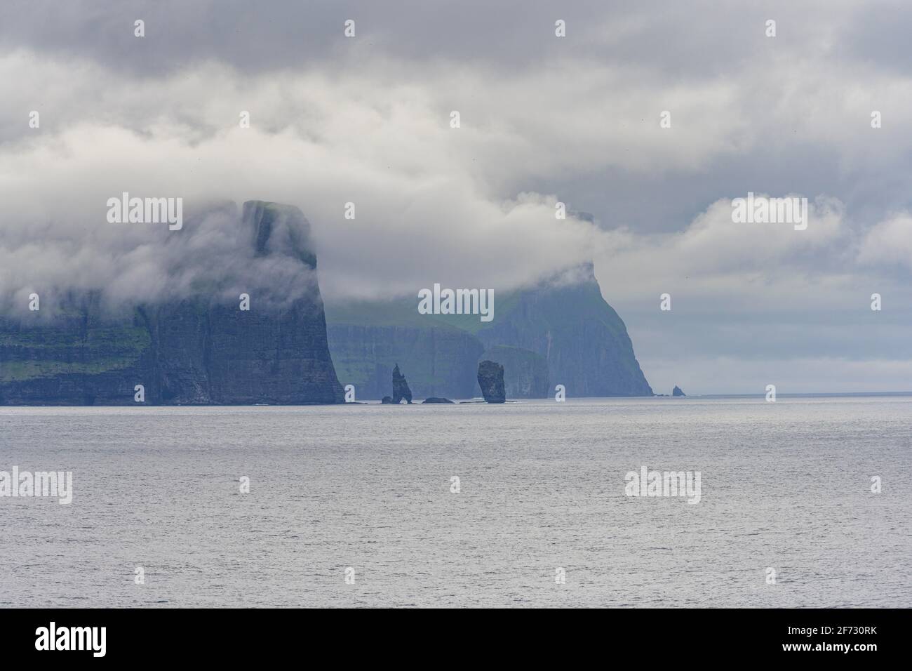 Risin and Kellingin rock needles next to 350m high cliffs, Esturoy, Faroe Islands Stock Photo