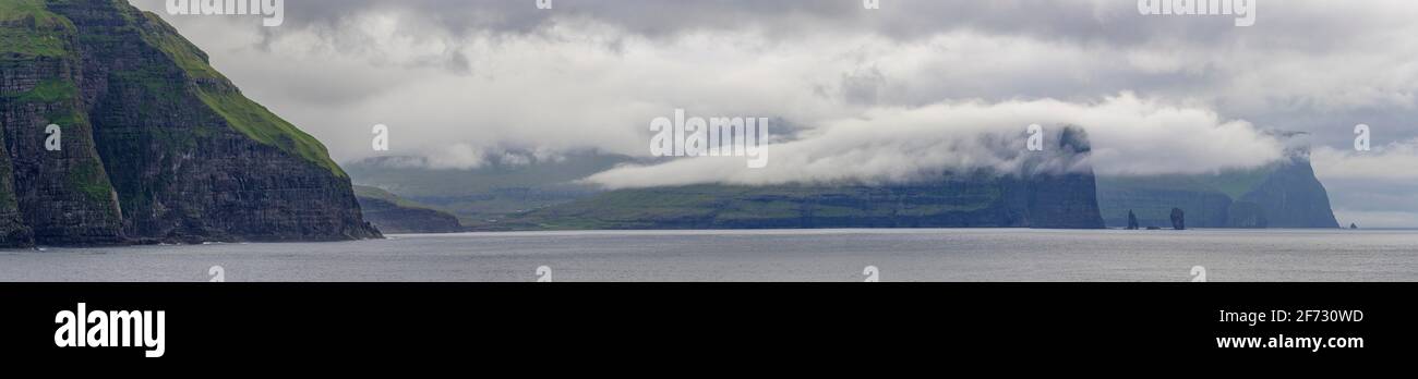 Risin and Kellingin rock needles next to 350m high cliffs, Esturoy, Faroe Islands Stock Photo