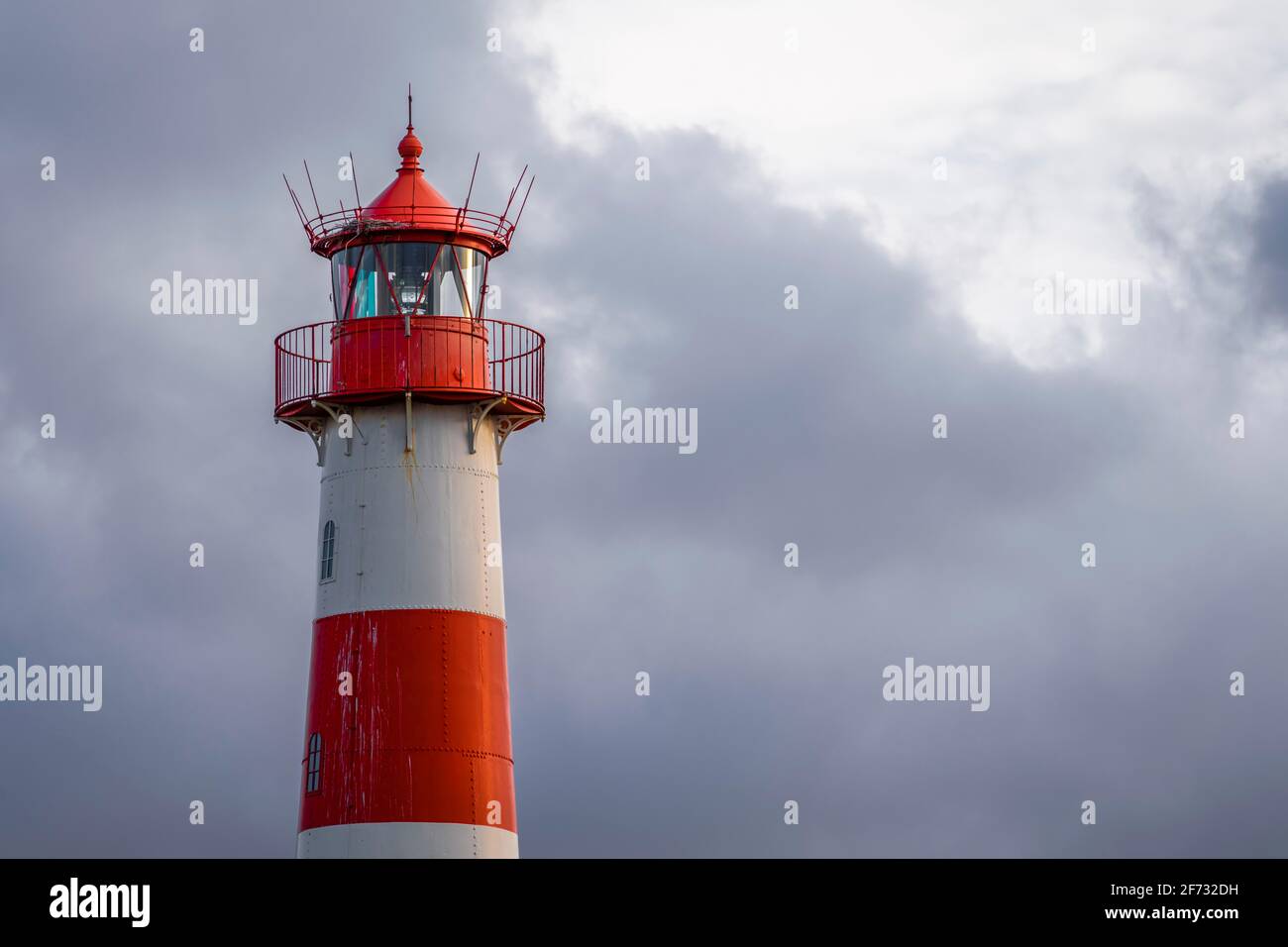 Red-white lighthouse List-Ost in front of dark sky, Ellenbogen, Sylt, North Frisian Island, North Sea, North Frisia, Schleswig-Holstein, Germany Stock Photo