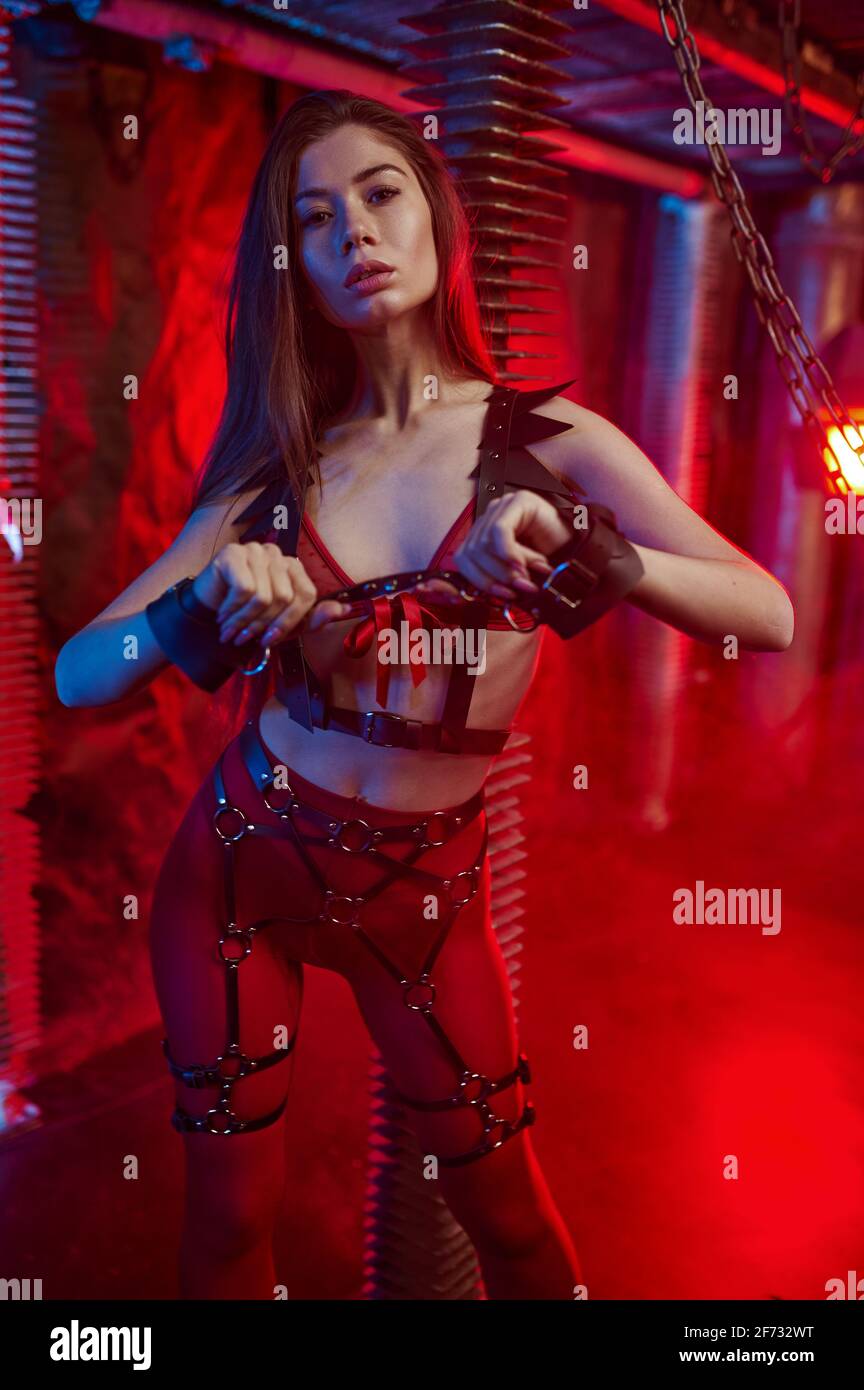 Sexy woman in red bdsm suit holds leather whip Stock Photo - Alamy