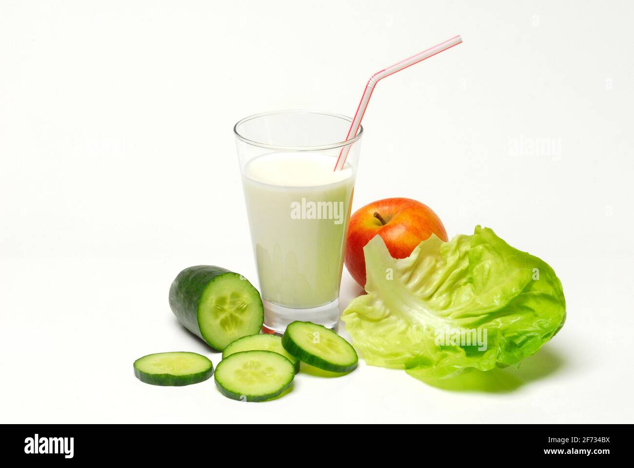 Glass of buttermilk, cucumber, lettuce leaf and apple, milk, straw