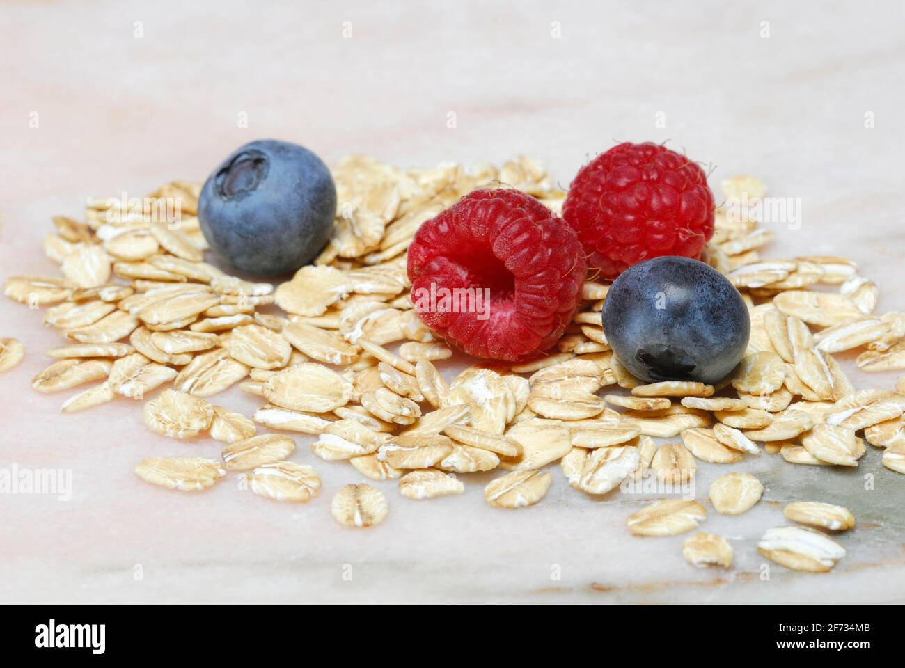 Oat flakes and berries, raspberries, blueberries, oats Stock Photo Alamy