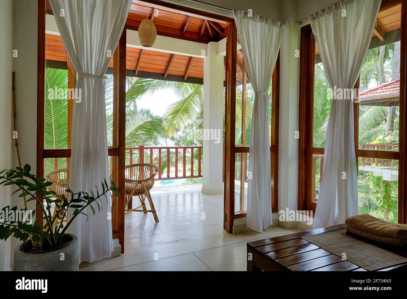 Tangalle, Sri Lanka - Nov 2, 2017: Hotel or residential house in tropical garden, room with terrace, windows and sea beach view. Home interior in Indi Stock Photo
