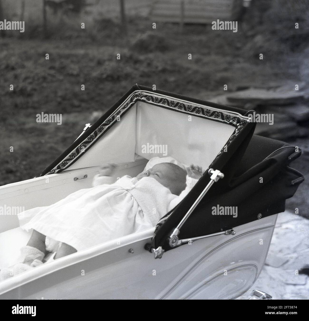 1958, historical, outside in a coachbuilt pram or babycarriage of the