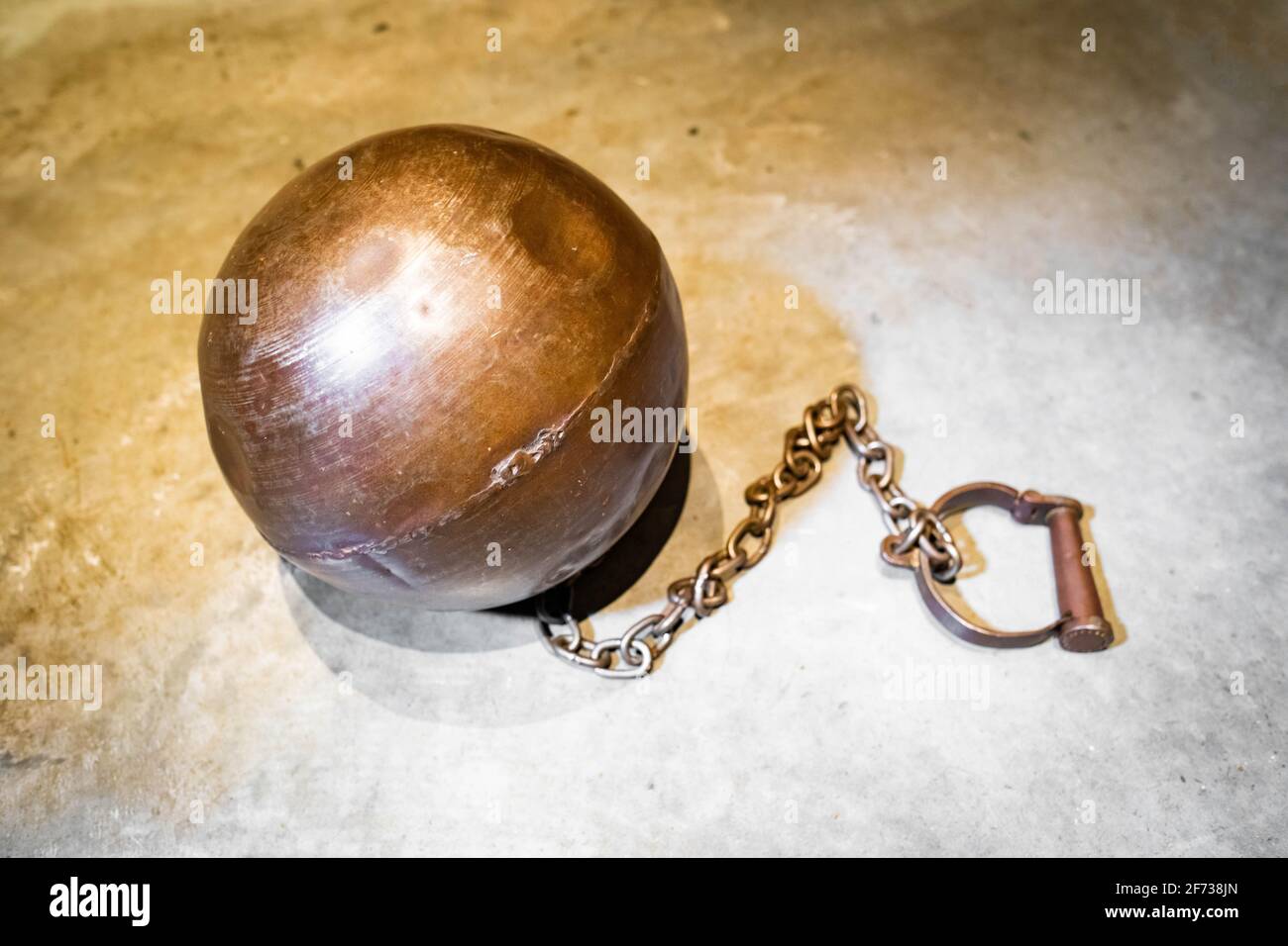 Heavy steel ball with legcuff chain for prisoners on the floor Stock Photo  - Alamy