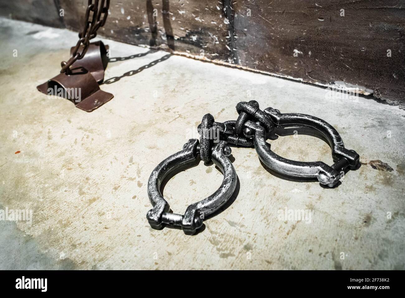 Heavy hand cuffs on the prison floor human slavery concept Stock Photo