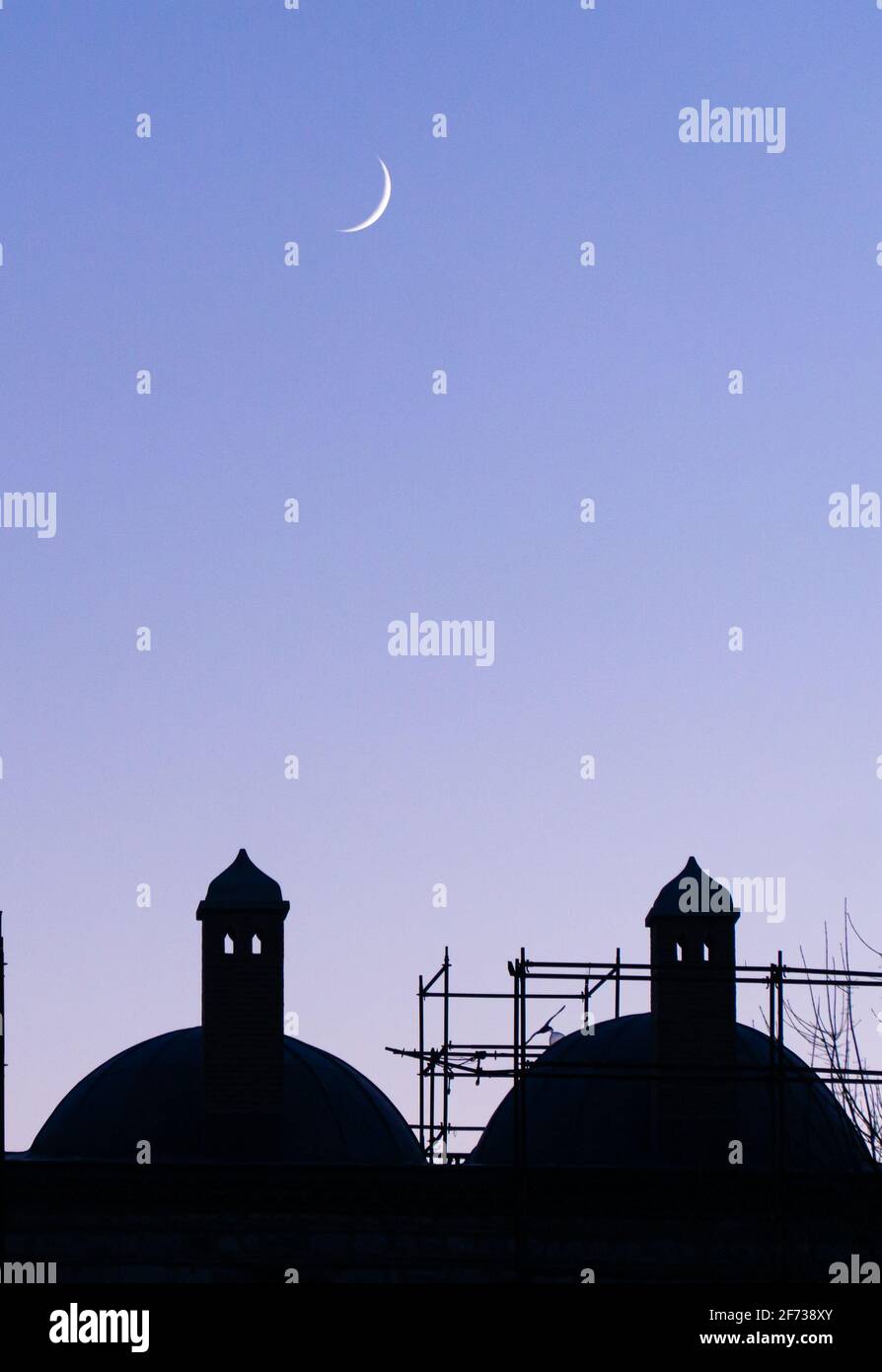 crescent moon over silhouetted domes Stock Photo