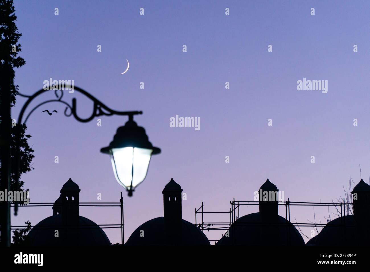 photo of crescent moon and street lamp with Ramadan evening feeling Stock Photo