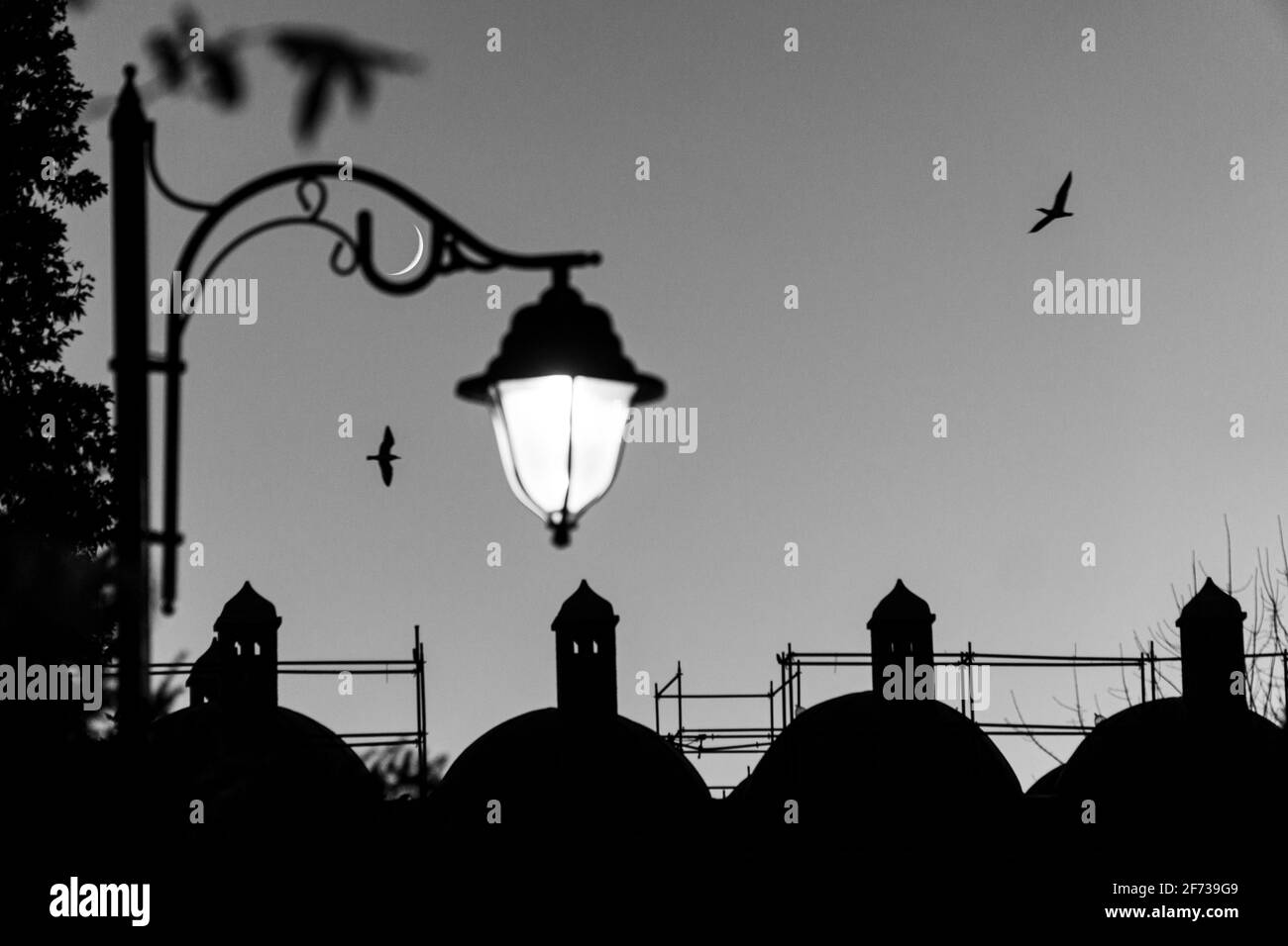 photo of crescent moon and street lamp with ramadan evening feeling Stock Photo