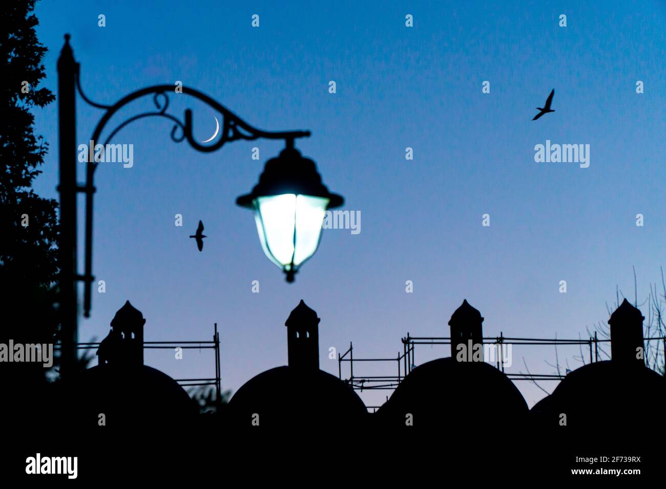 photo of crescent moon and street lamp with ramadan evening feeling Stock Photo
