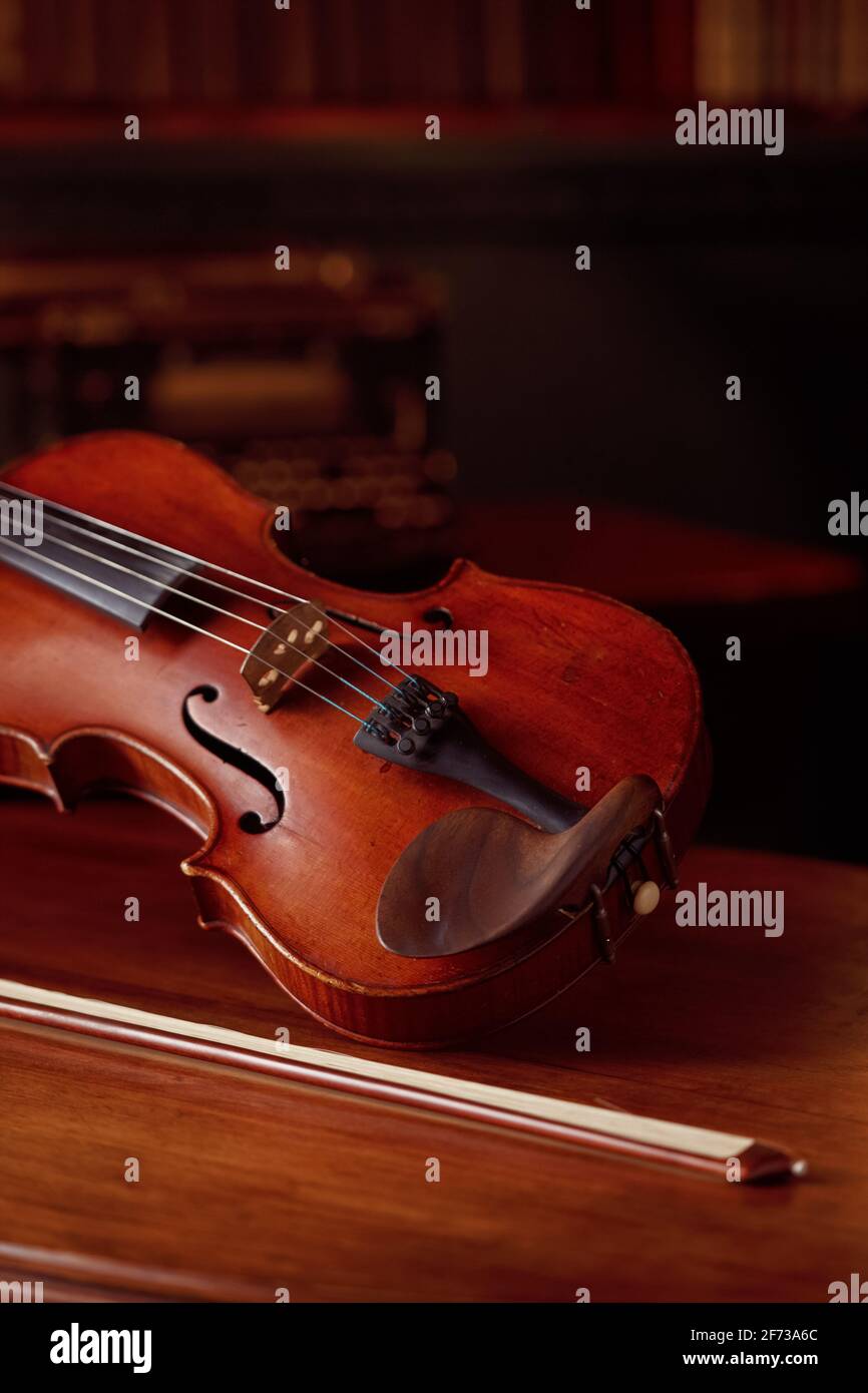 Violin in retro style and bow on wooden table Stock Photo