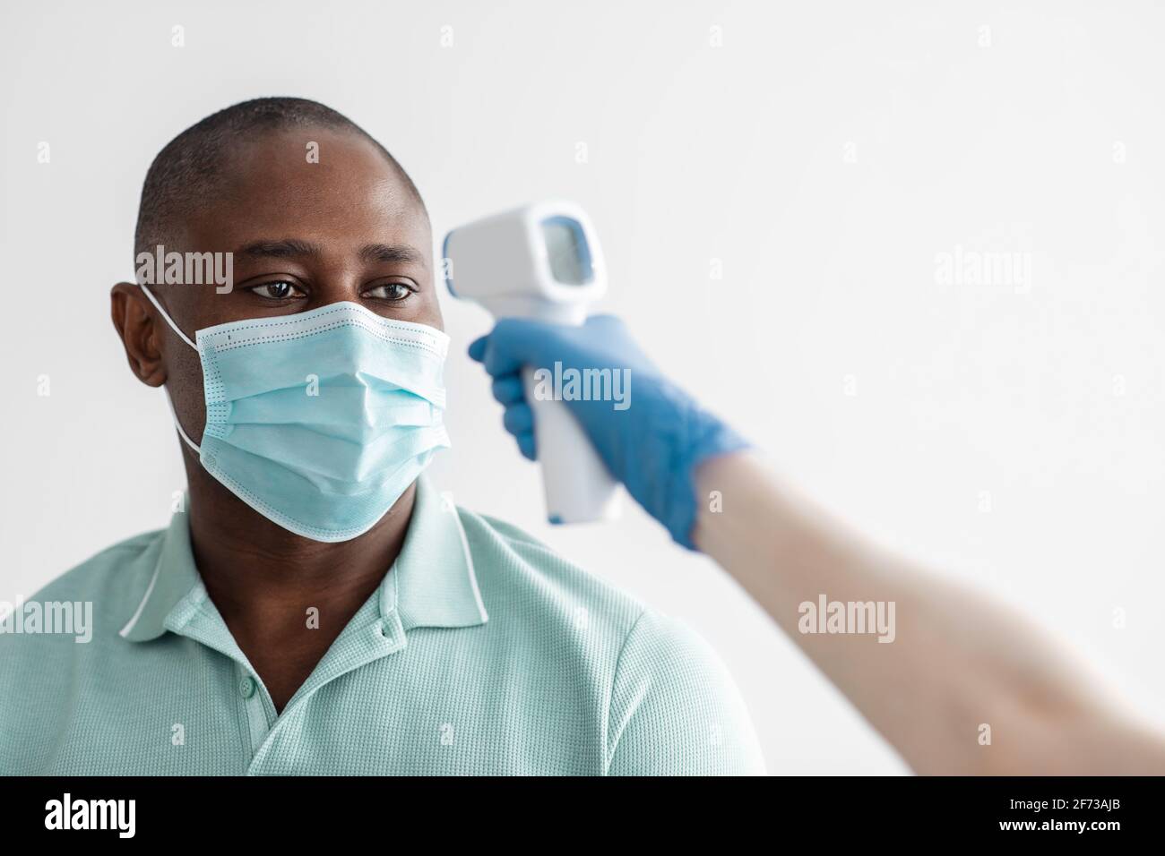 Nurse measures body temperature with infrared thermometer in middle