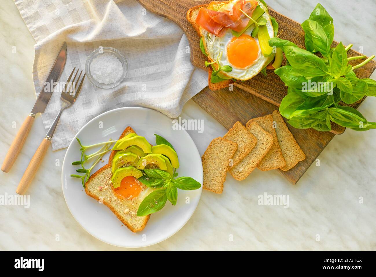 Tasty fried eggs with bread and avocado on table Stock Photo