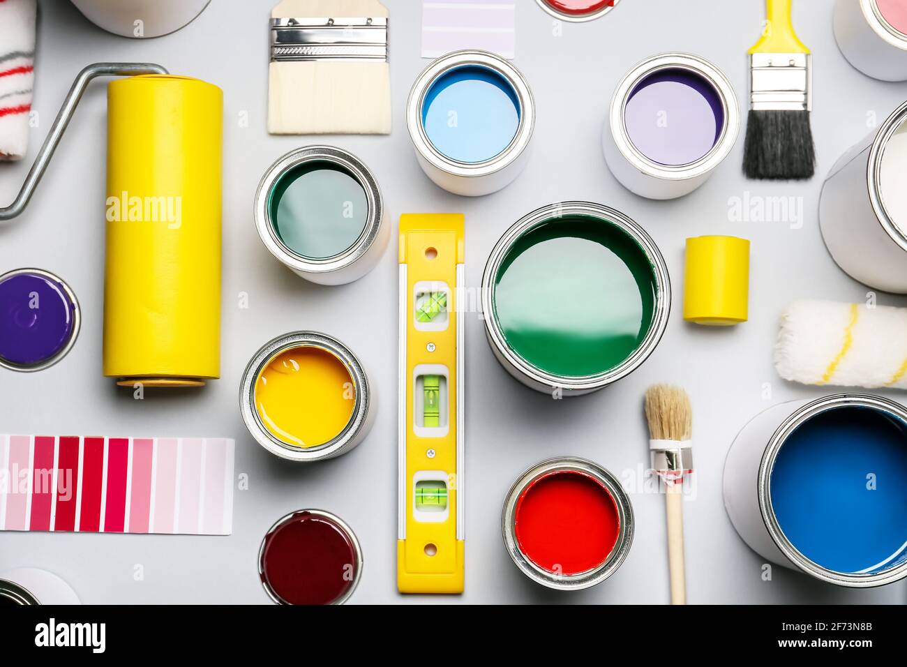 Cans of paints and tools on light background Stock Photo - Alamy