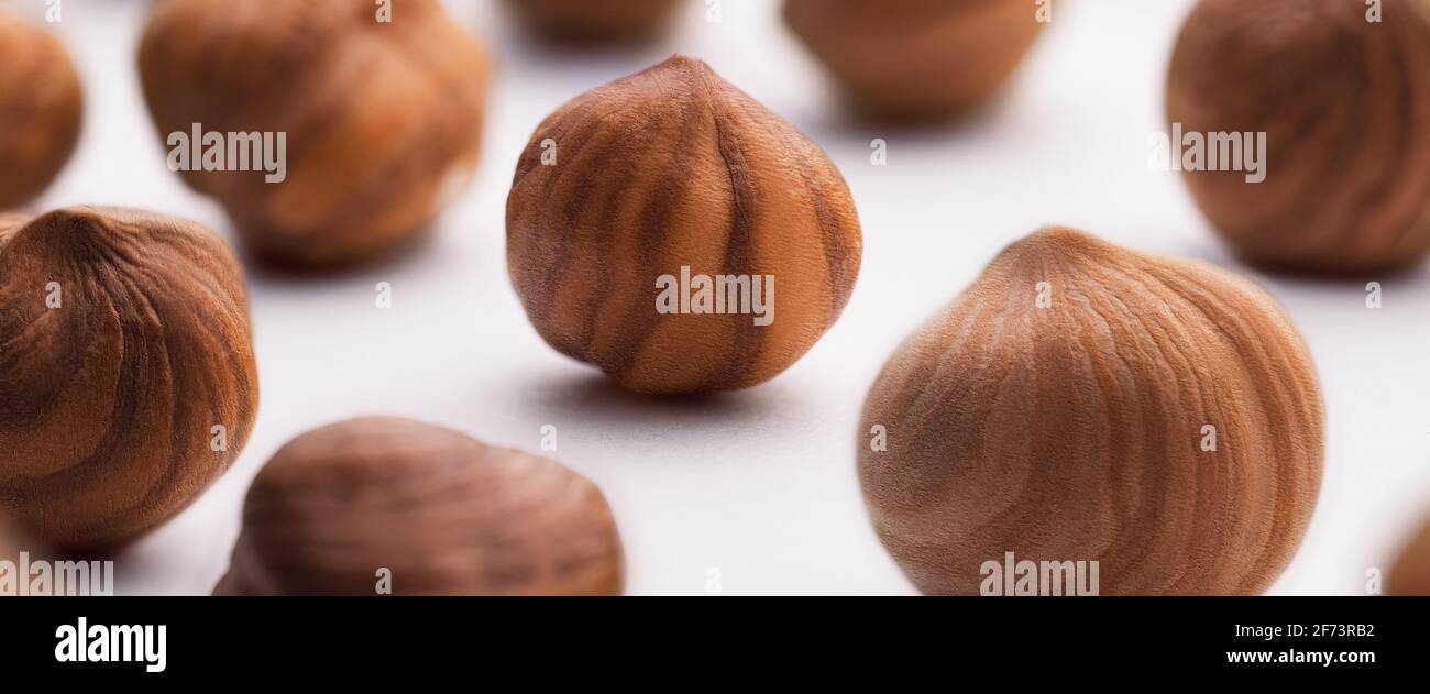 Hazelnuts scattered on a white background, whole, selective focus. The concept of healthy eating. Stock Photo