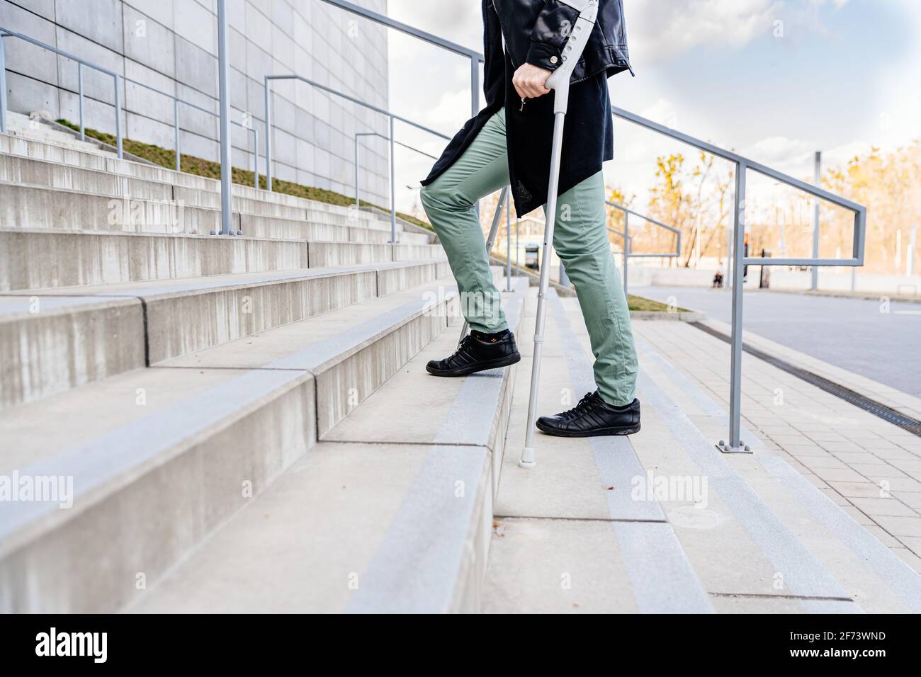 Injured man trying to walk on crutches up the stairs Stock Photo Alamy