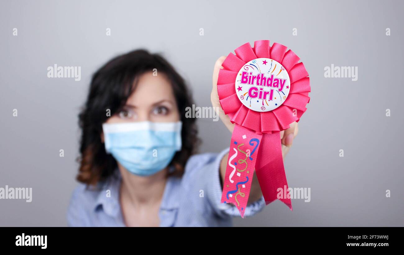 Woman wearing protection face mask against coronavirus. Woman in a mask with party supply. Birthday girl. Medical mask, Close up shot, Select focus, P Stock Photo