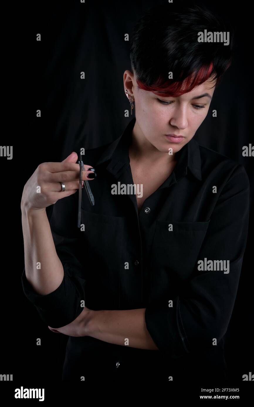 Woman With Straight Razor Half length portrait of young adult barber woman on black background ...