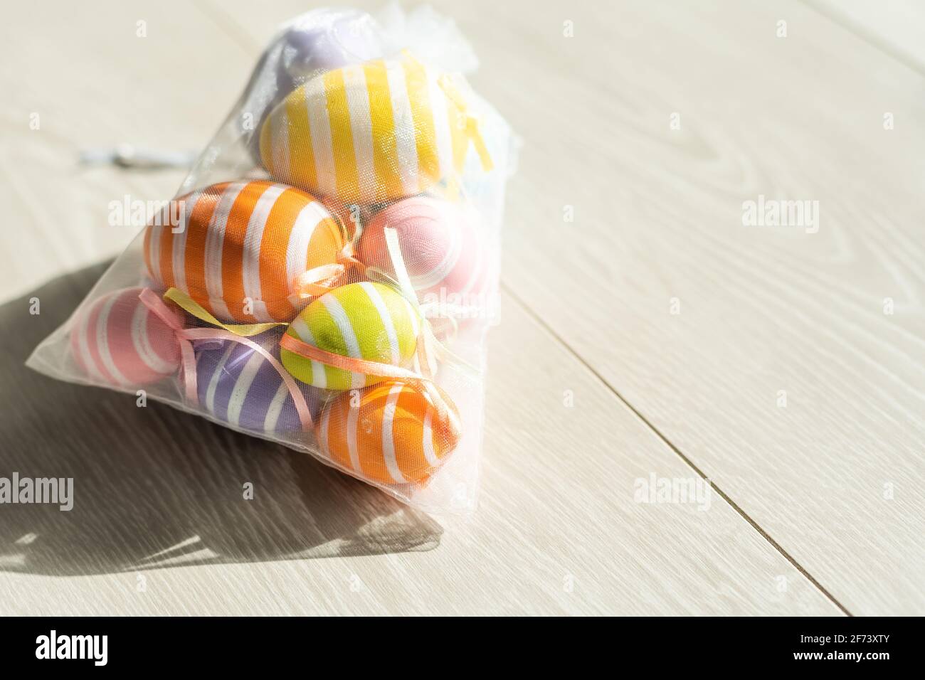 multi-colored chicken eggs in bag mesh on white background. easter Stock Photo