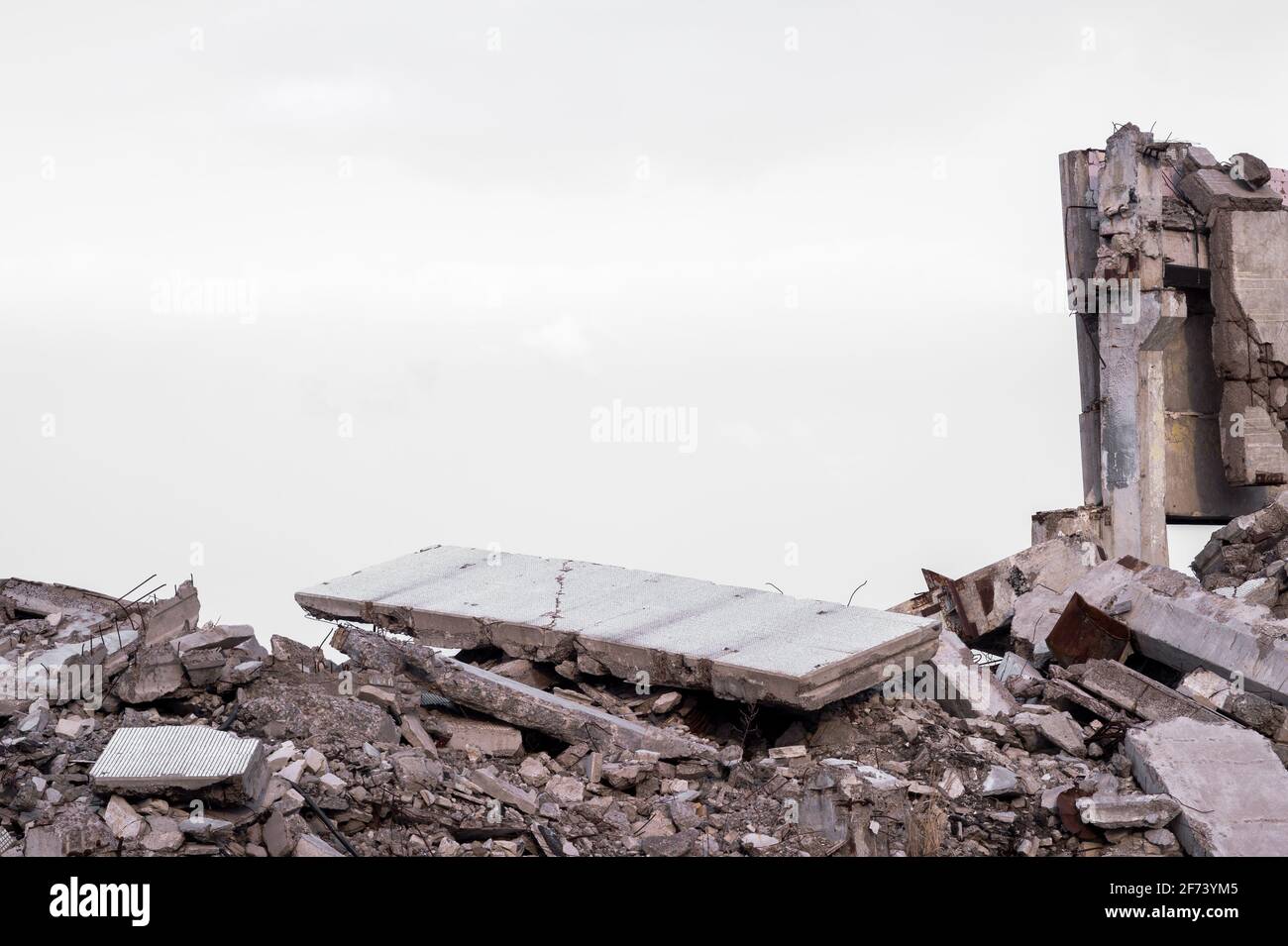 Slab Rubble A gray concrete slab lies on top of a pile of rubble against the ...