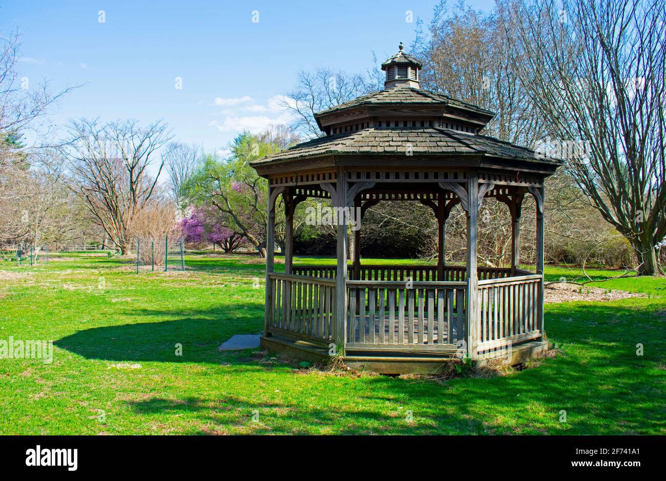 Wooden gazebo at Rutgers Gardens against a background of new plant growth on a sunny day in Springtime  -02 Stock Photo