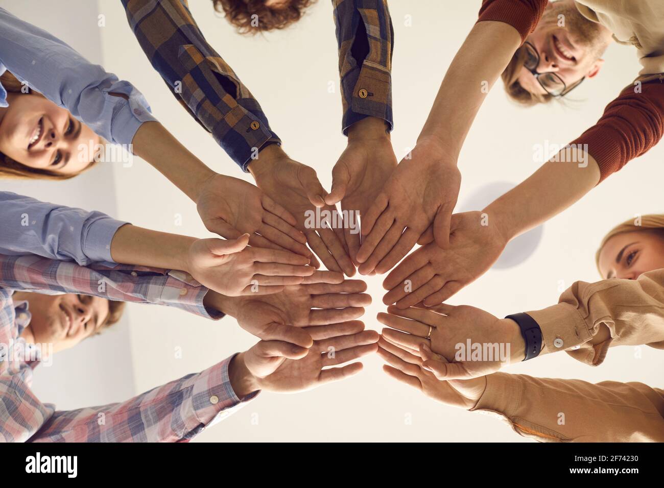 Close up bottom view of people putting hands together standing in circle Stock Photo
