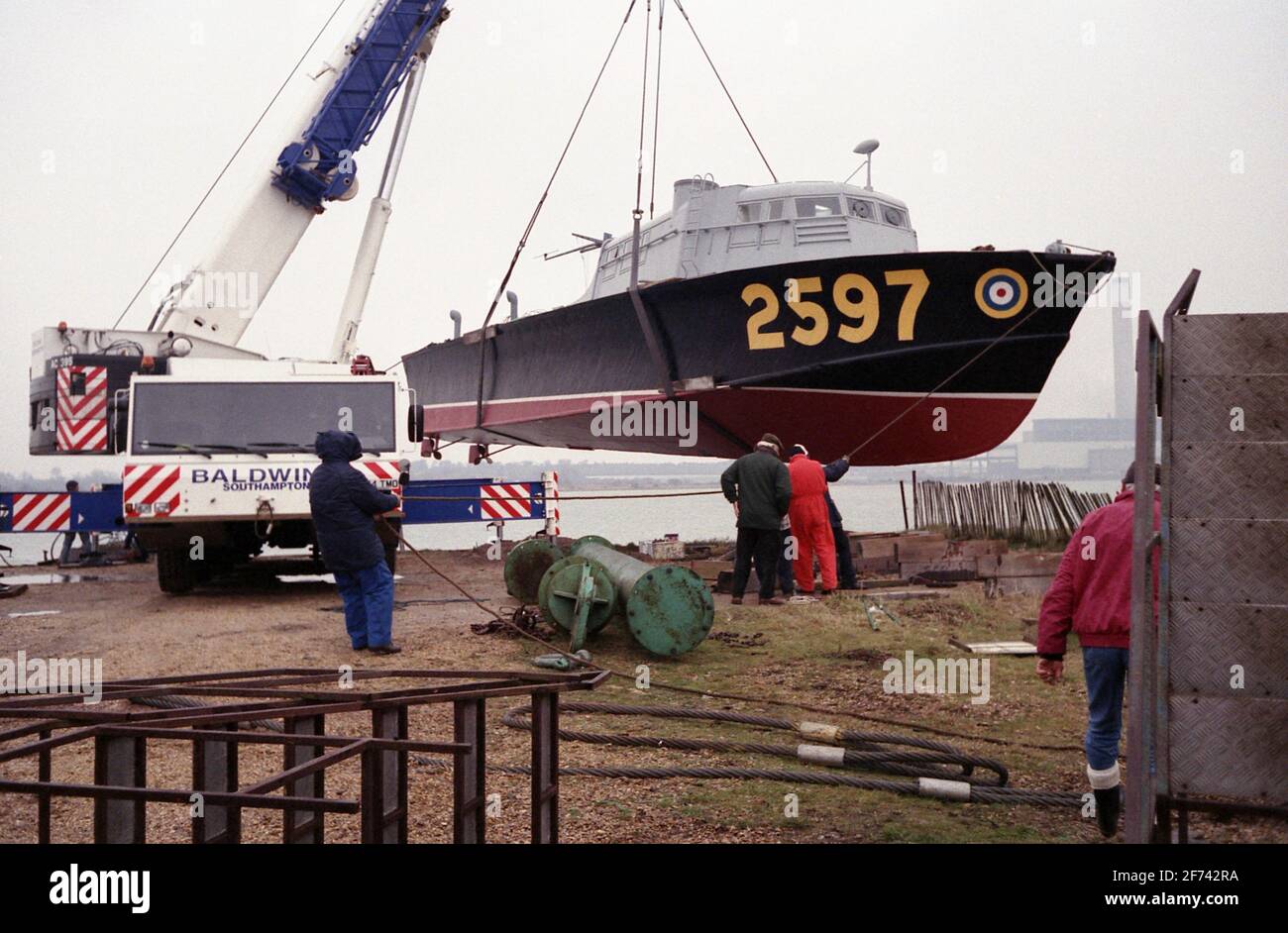 AJAXNETPHOTO. 7TH FEBRUARY, 1996. CALSHOT, ENGLAND. -ASR LIFT - AIR SEA RESCUE CRAFT 2597 BEING LIFTED INTO THE WATER AT CALSHOT SPIT AHEAD OF TOW TO THE HAMBLE RIVER AND A NEW MOORING.  PHOTO: JONATHAN EASTLAND/AJAX  REF:960702 27 Stock Photo