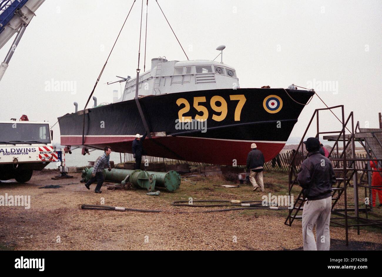 AJAXNETPHOTO. 7TH FEBRUARY, 1996. CALSHOT, ENGLAND. -ASR LIFT - AIR SEA RESCUE CRAFT 2597 BEING LIFTED INTO THE WATER AT CALSHOT SPIT AHEAD OF TOW TO THE HAMBLE RIVER AND A NEW MOORING.  PHOTO: JONATHAN EASTLAND/AJAX  REF:960702 28 Stock Photo